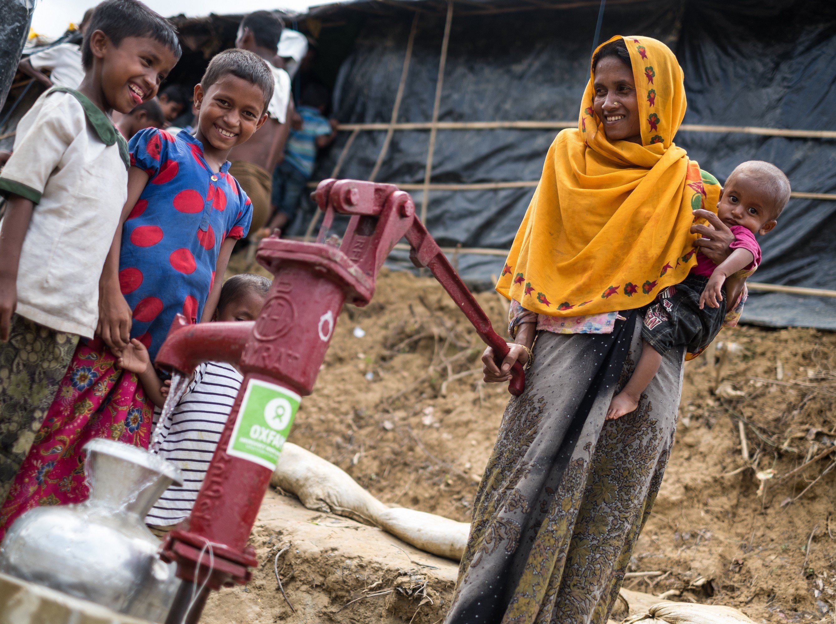 A mother and children at one of Oxfam's water pumps in a Rohingya refugee camp.